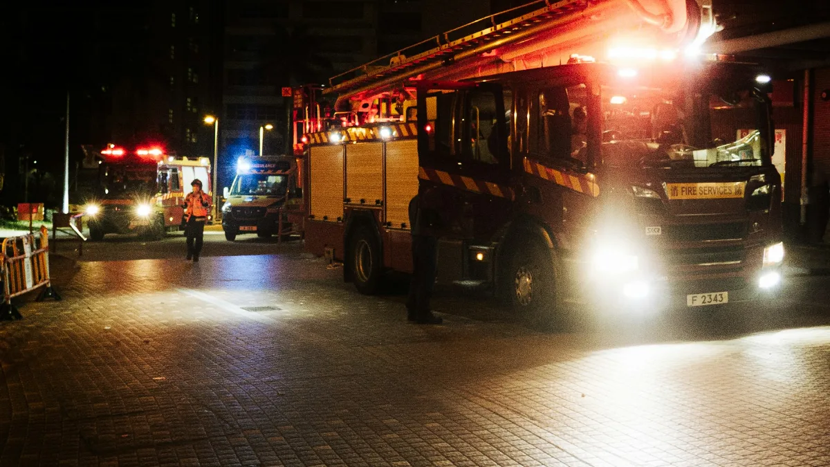 Caminhão de bombeiros e viaturas de resgate com luzes acesas à noite