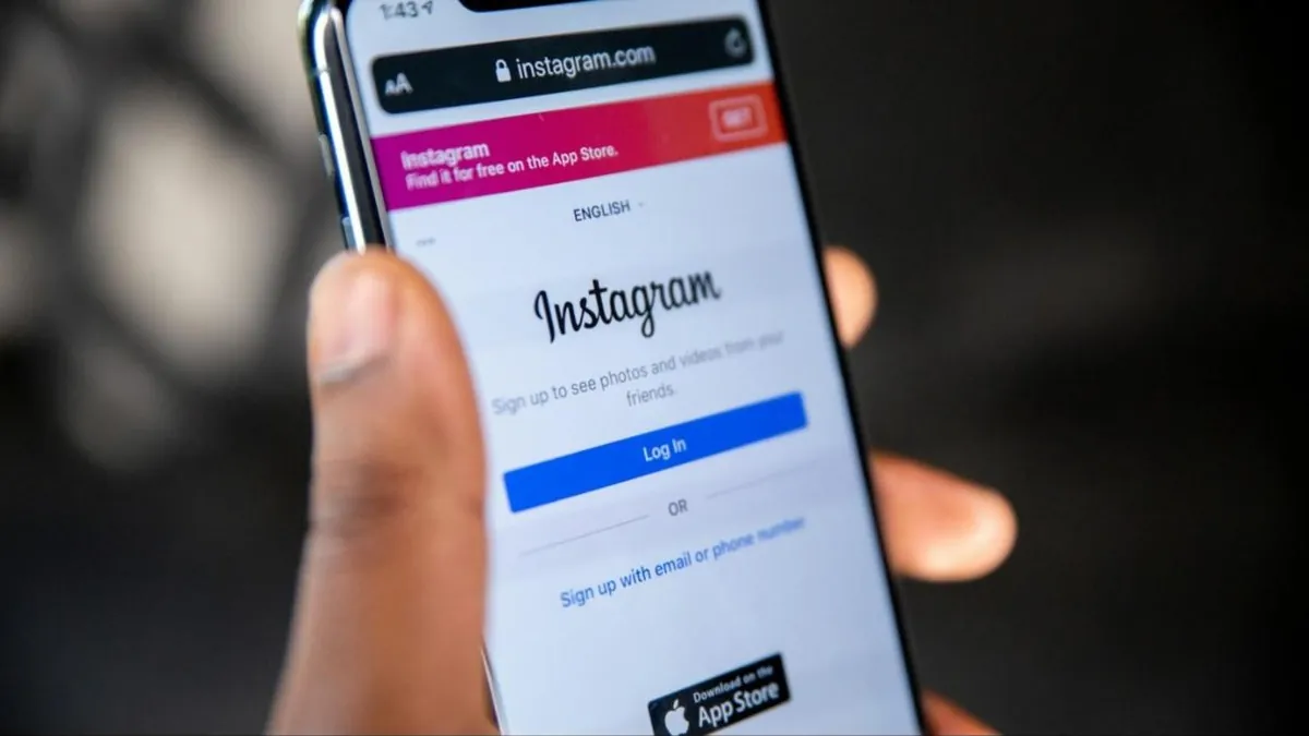 Pessoa segura celular com a tela de login do Instagram