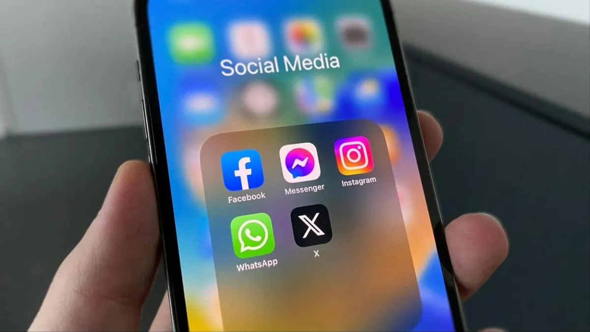 Celular com pasta de aplicativos de redes sociais: Facebook, Instagram, WhatsApp, Messenger e X