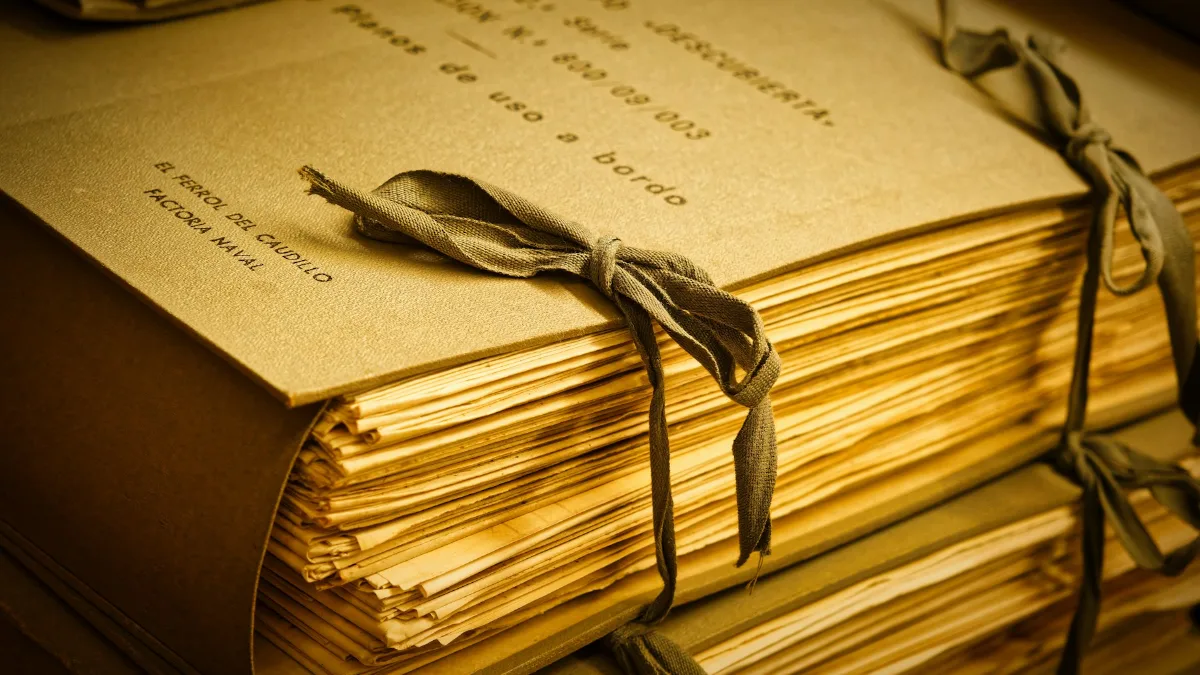 Pilhas de processos e pastas de papel amarradas com barbante